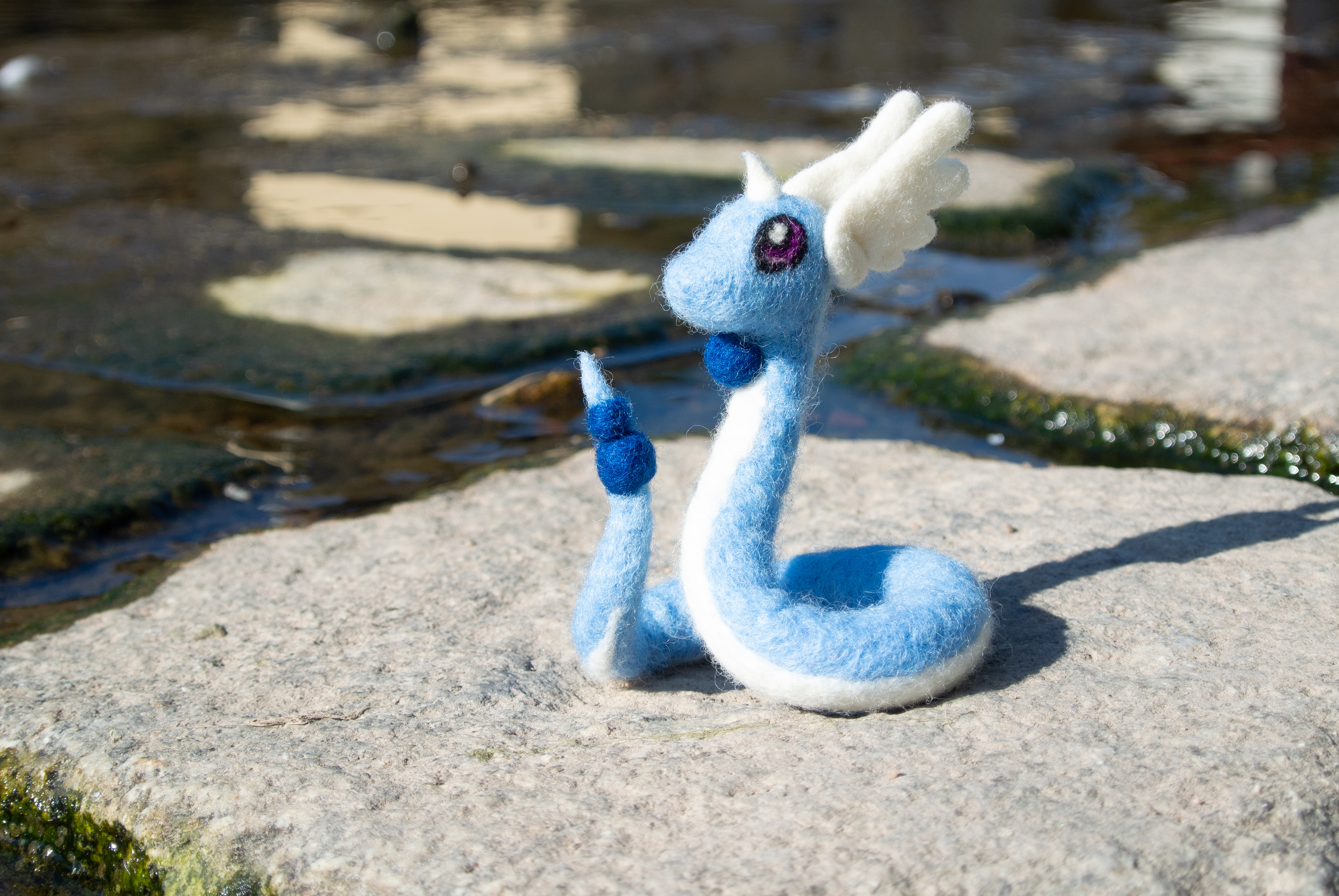 Gefilztes Pokémon Dragonir sitzt in der Sonne auf einem Stein