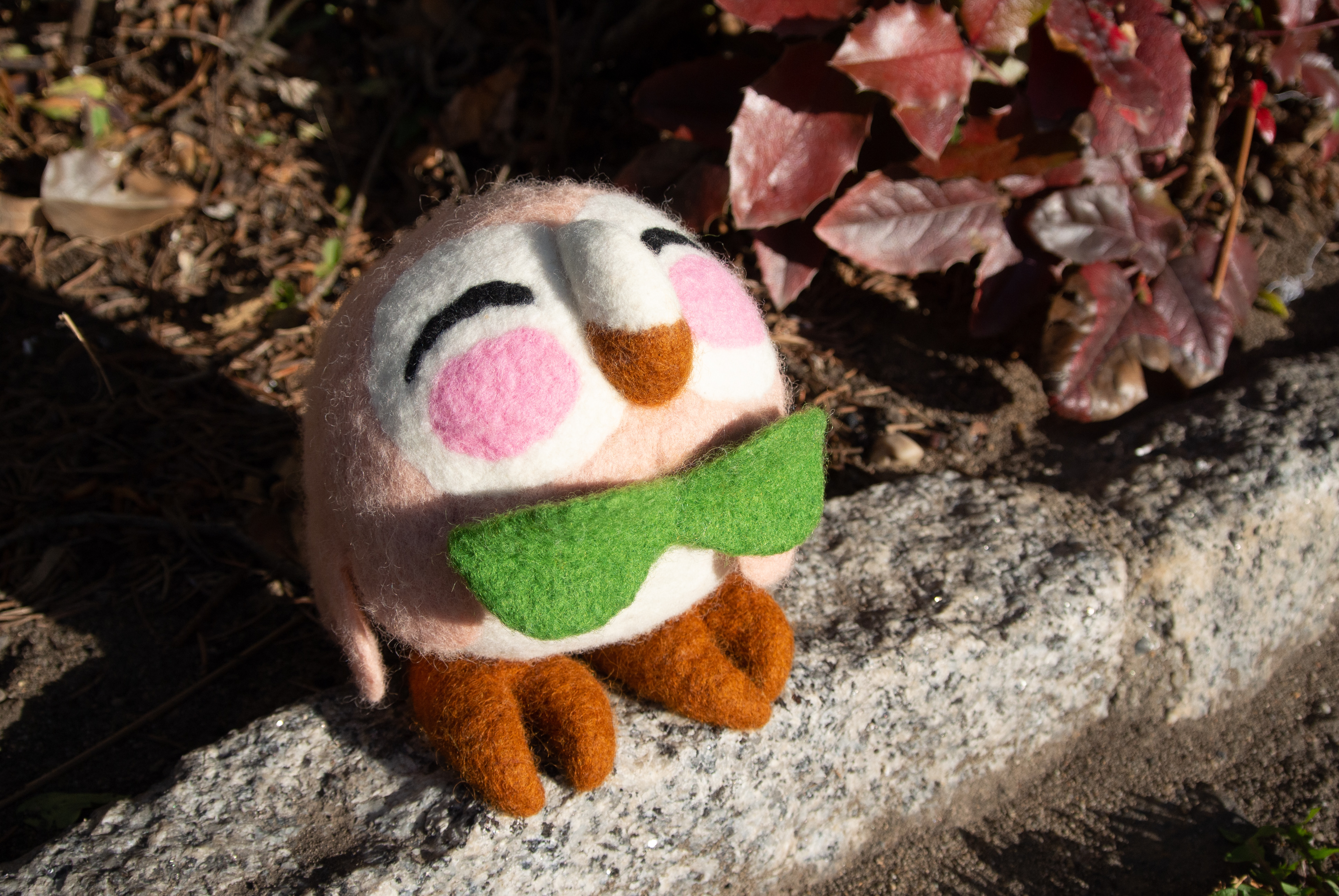 Gefilztes Pokémon Bauz sitzt auf einem Bordstein in der Sonne